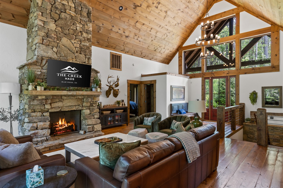 A cozy mountain retreat featuring a stunning stone fireplace, vaulted ceilings, and rustic-modern decor, perfect for relaxing or entertaining in style.