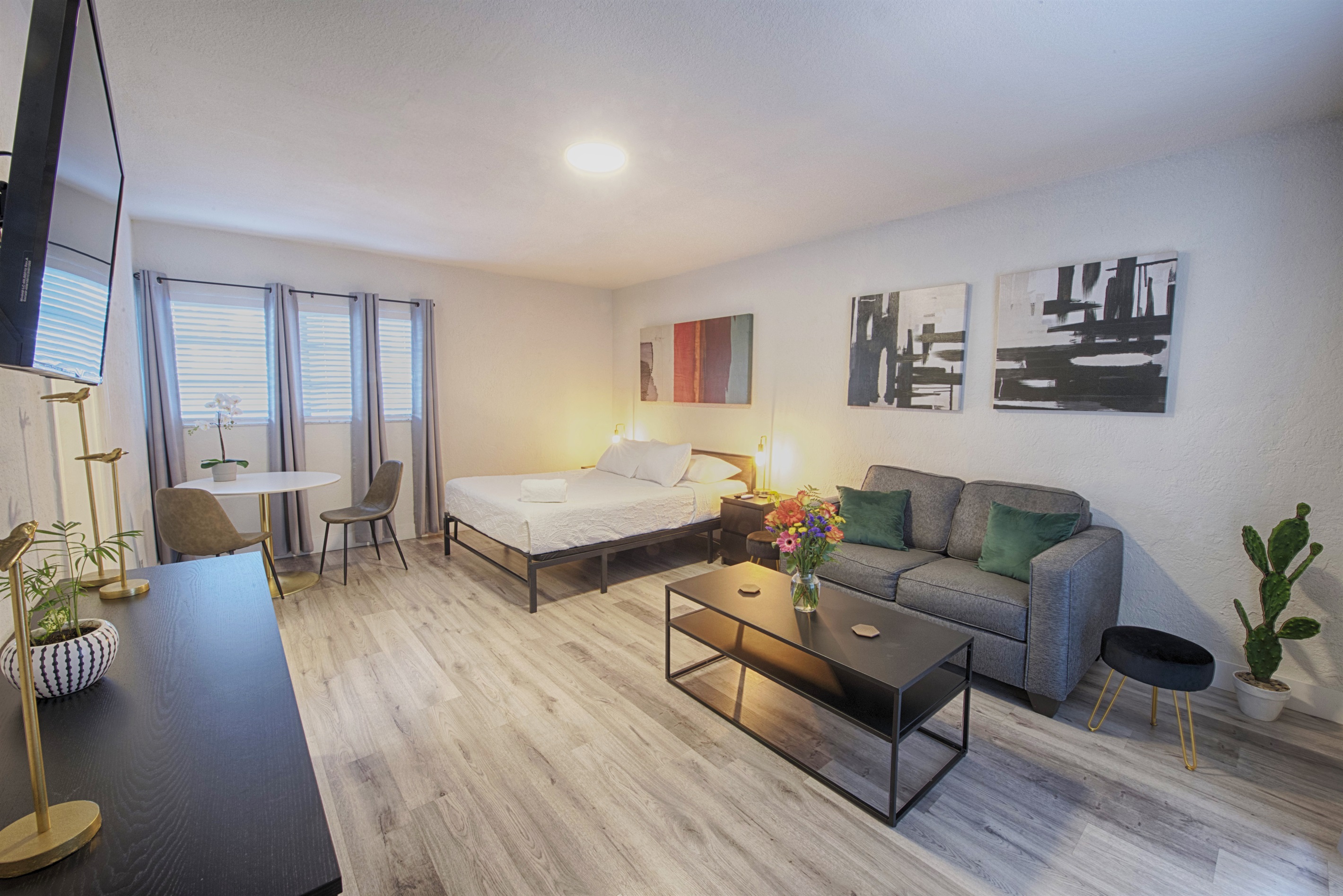 Beautiful home touches include gray accent chair, ottoman, black out curtains and dresser