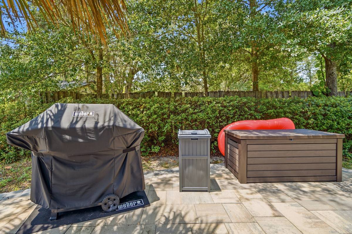 A backyard grill is available for easy cookouts beside the outdoor dining area.