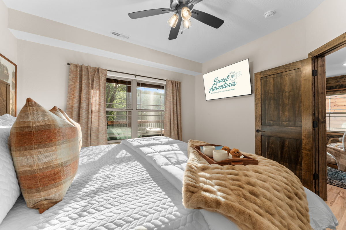 Unwind in the main level bedroom with a luxury king bed, smart TV and a peek at the sun setting through the trees. This bedroom also has a private attached ensuite bathroom.