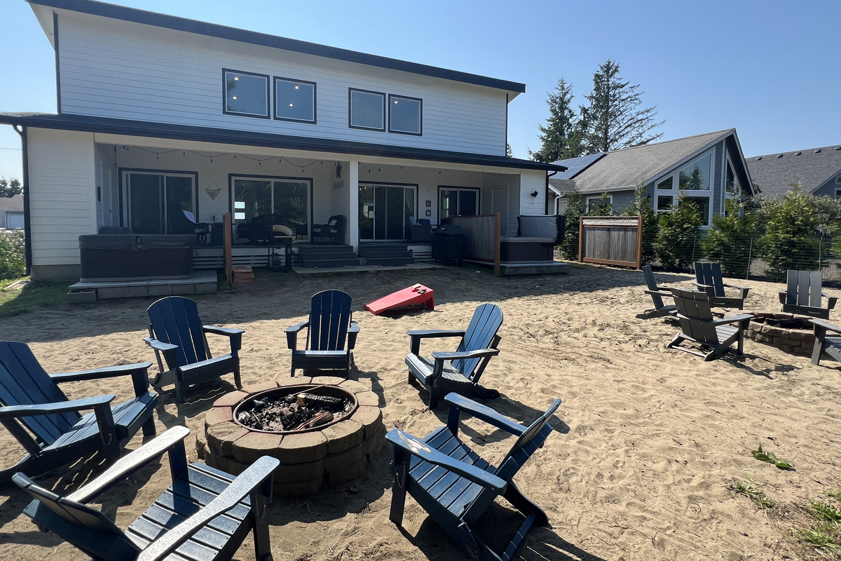 Both fire pits, both hot tubs, and a full cornhole set — one big shared backyard when you book the whole place.