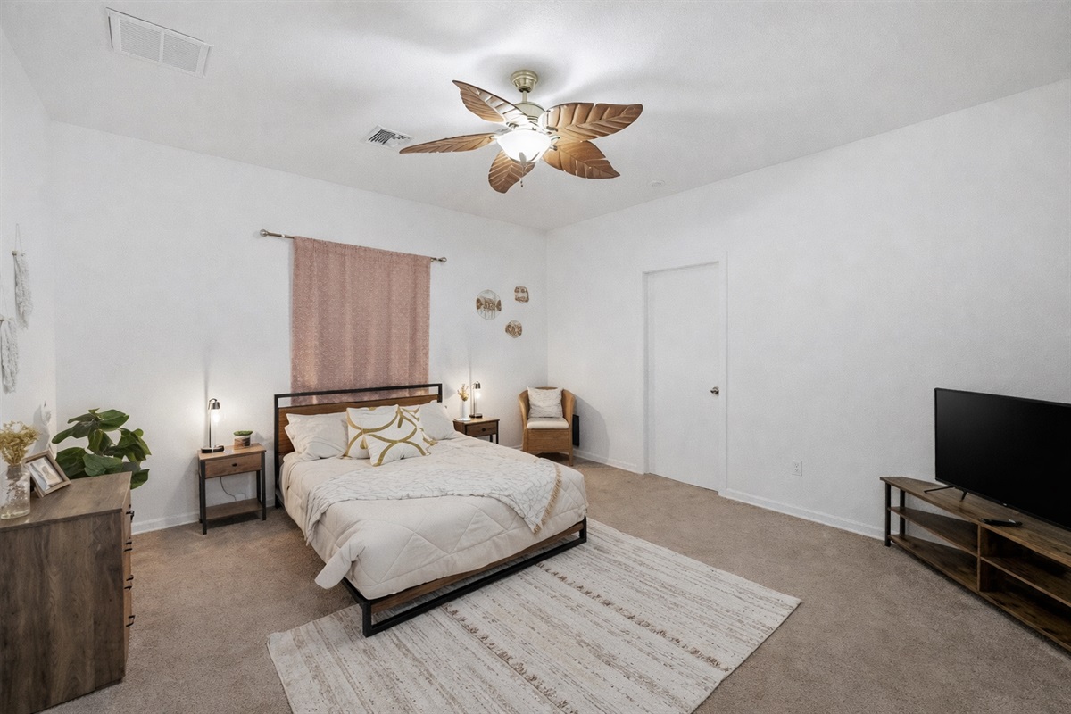 This serene bedroom blends soft earth tones, boho-chic decor, and an en-suite bath for a restful stay with comfort and style.