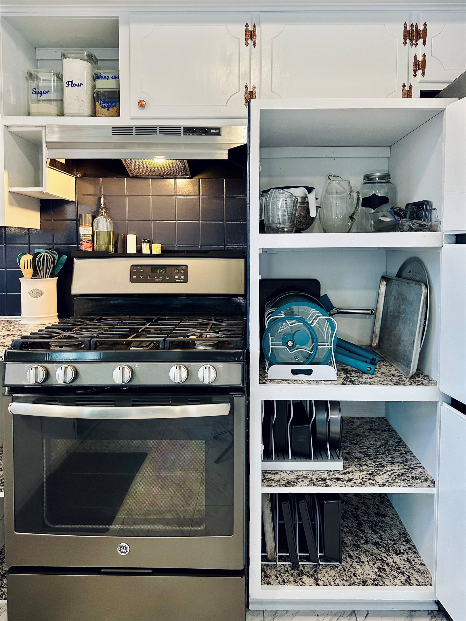 Kitchen cabinets stocked for real cooking, including pantry staples (upper left) mixing bowls and kitchen tools (top right shelf), pots and pans (second shelf), and baking pans and cookie sheets (lower shelves). Equipped for everyday meals and baking.