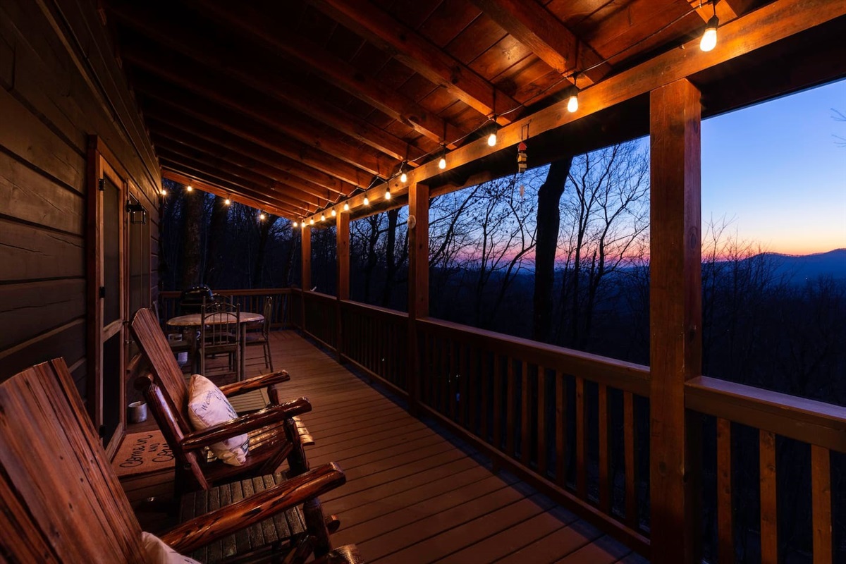 Our porch with an amazing west facing view of valley and mountains and sunset.  Rocking chairs and a swing for sitting and also and table for dining outside.  There is also a gas grill. The top deck looks down at the firepit area as well.