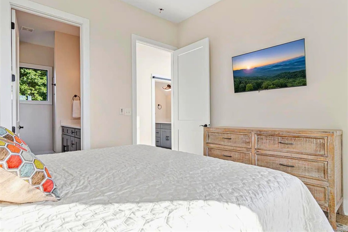 The primary bedroom’s en-suite bathroom adds a touch of luxury with its modern fixtures and spacious design.