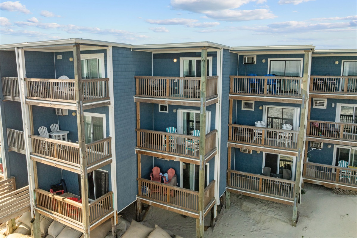 Exterior view of the oceanfront building with private balconies overlooking the beach