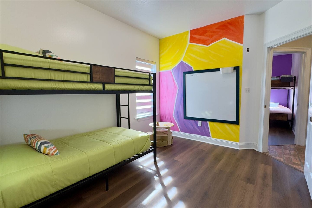 A doorway reveals another bunk room beyond, making this setup ideal for groups or families.