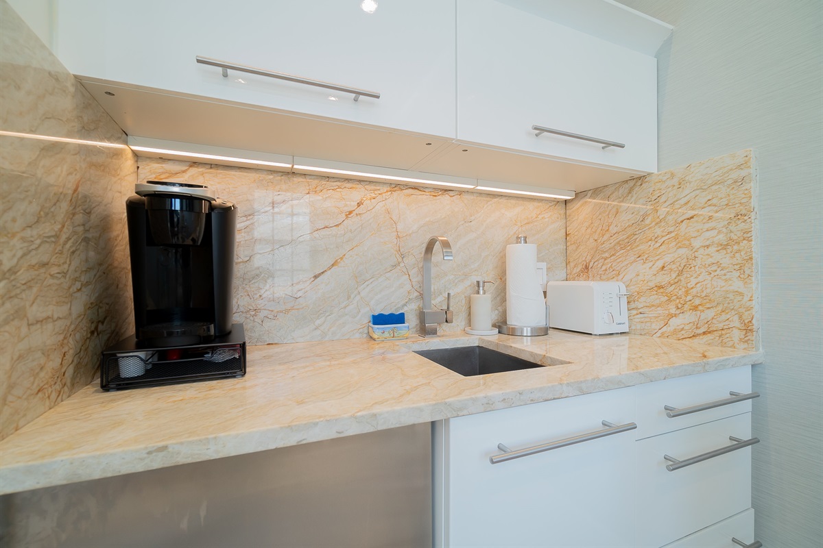 Kitchen w/lighted drawers, microwave, toaster, coffee maker & fridge.