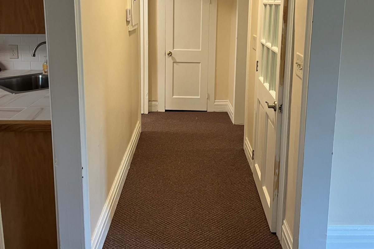Kitchen on left, living room on right, bathroom and Queen 2 at the end of the hall