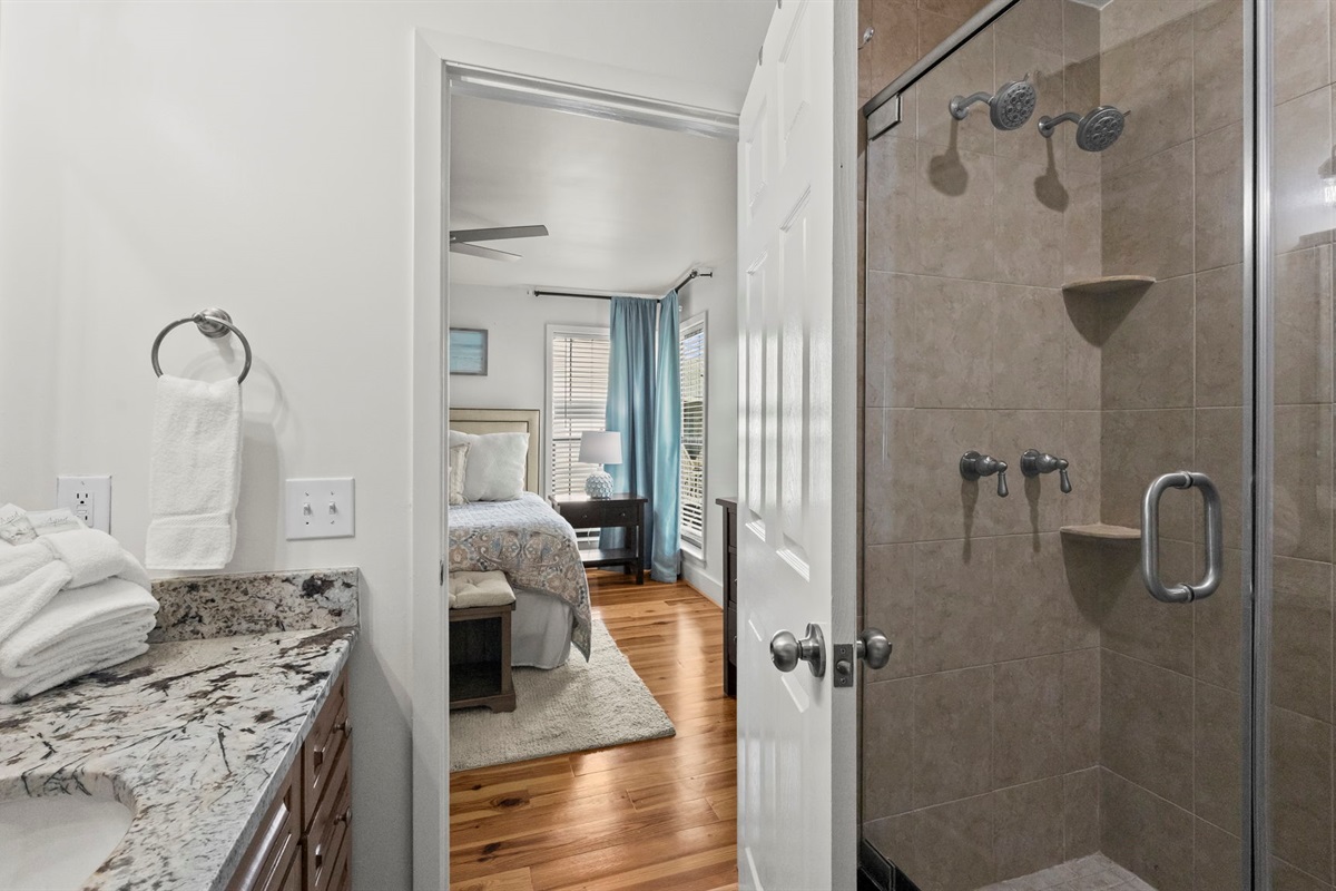 Indulge in the luxurious master en suite of our Cotton Bayou condo, featuring dual shower heads for a spa-like experience. This private retreat complements the spacious master suite, offering ultimate relaxation after a day by the pool or on the water.