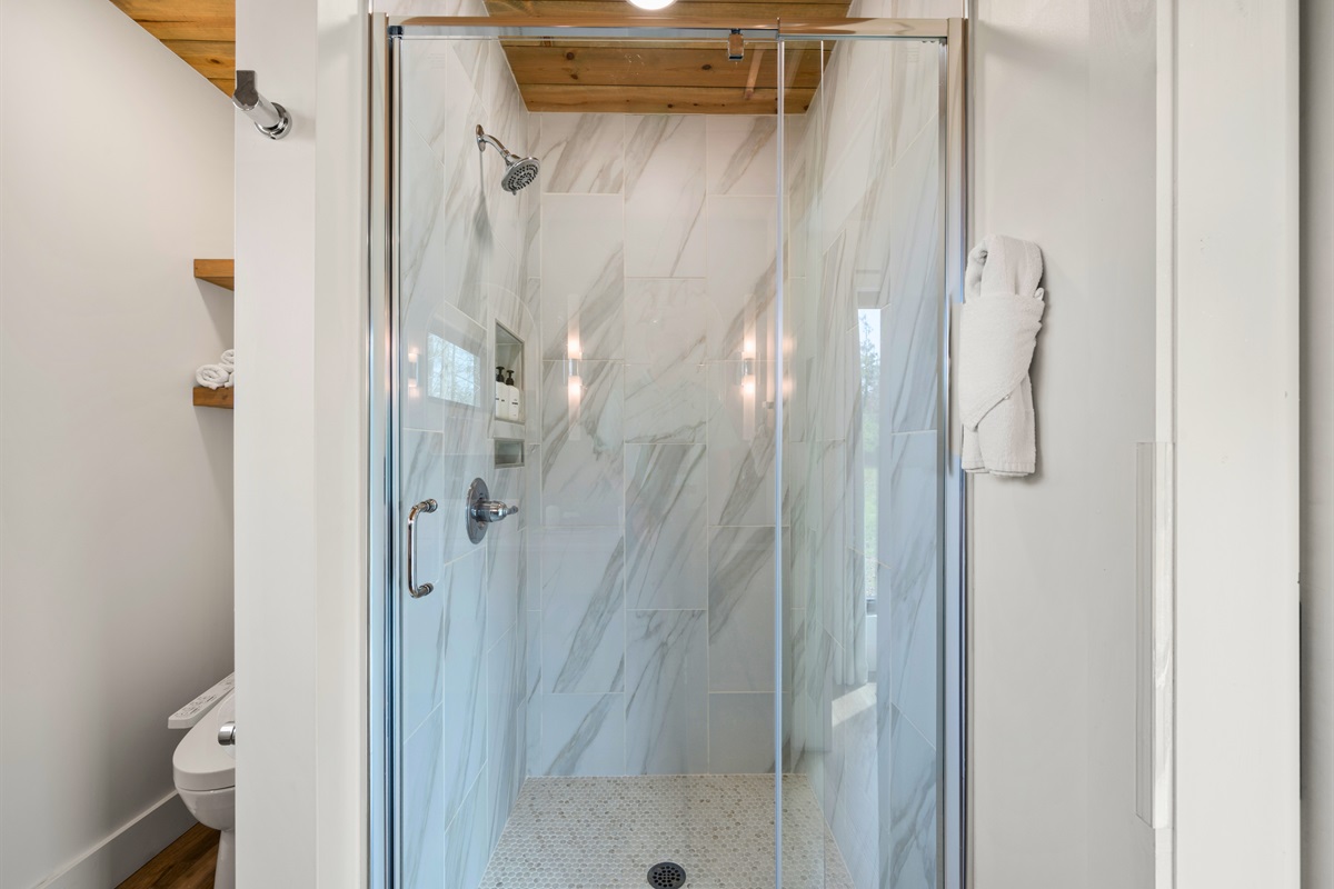 The glass shower creates an open, airy look while still offering plenty of space to relax and refresh.