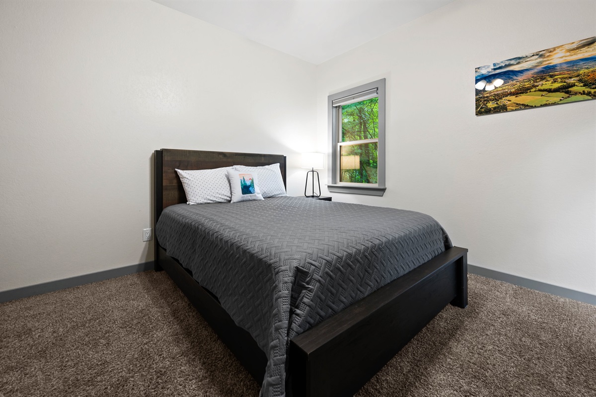 The downstairs bedroom has forest views, and a private balcony!