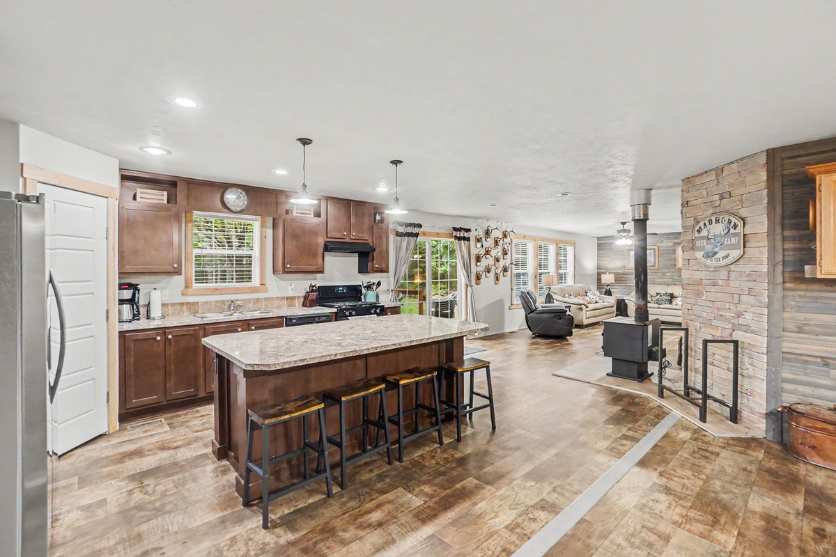 Kitchen with large island with bar stools.