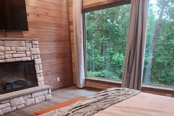Bedroom with king bed, wood paneling, and cozy decor