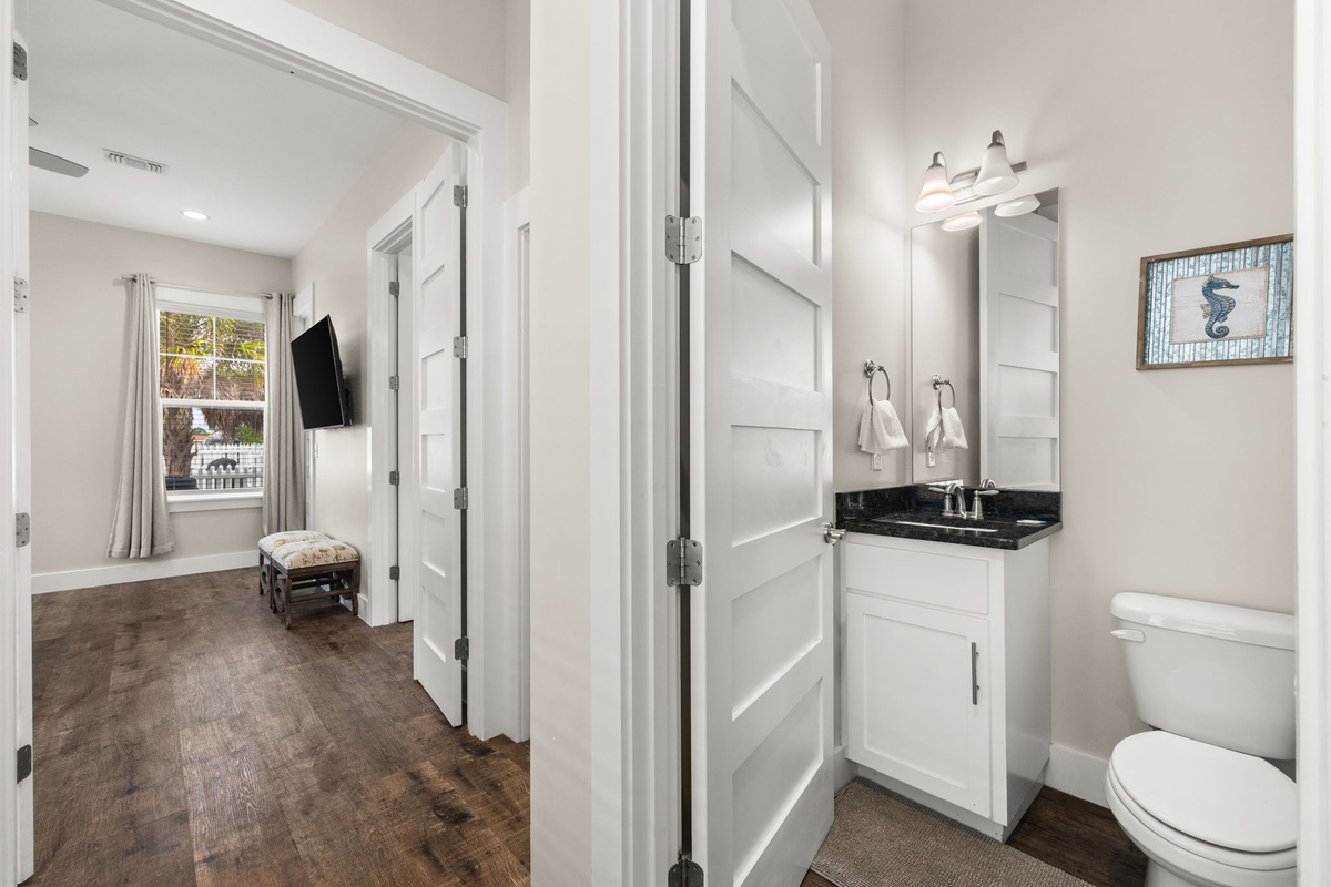 Convenient first-floor half bath located near kitchen, living room & pool access