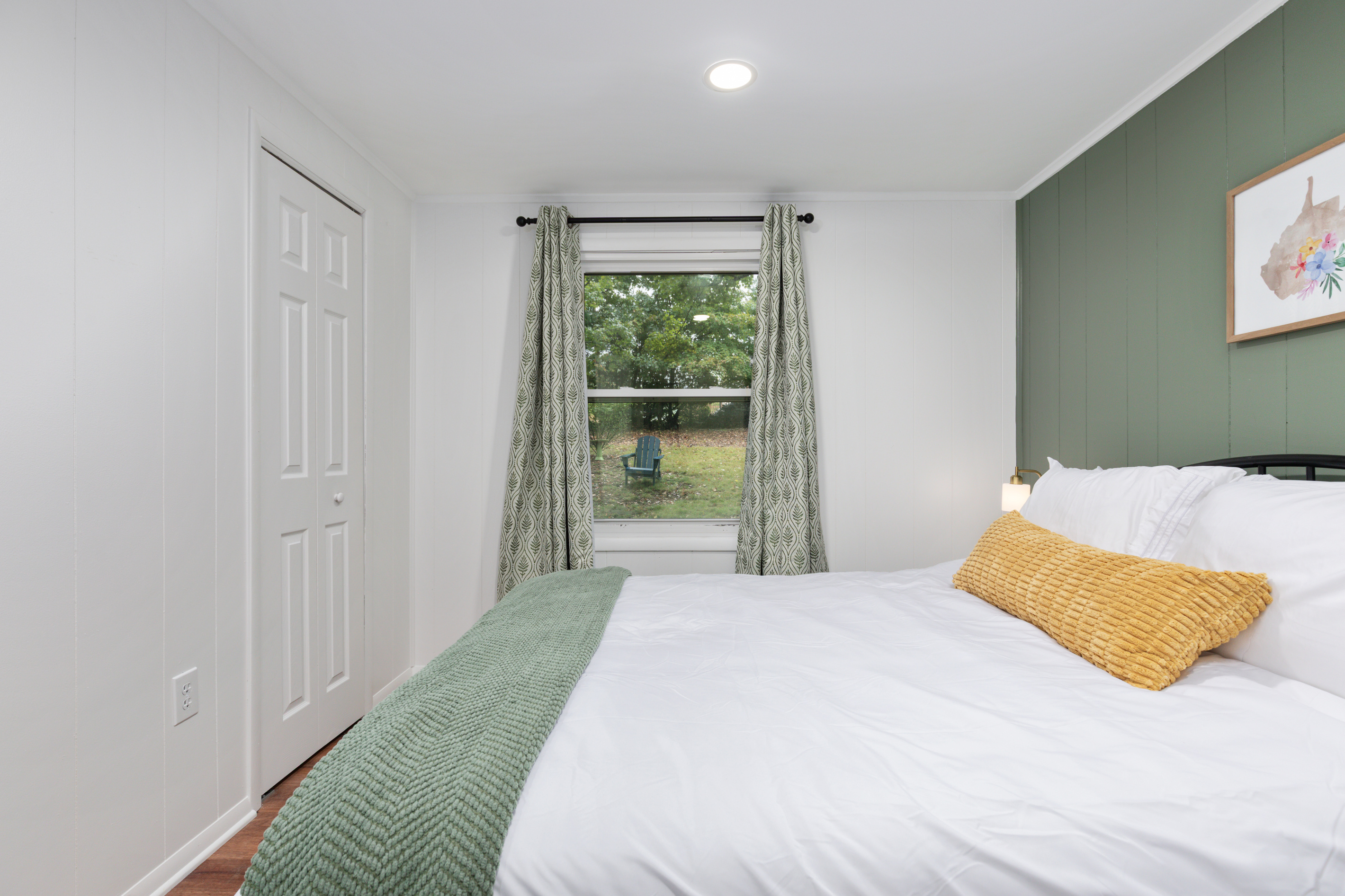 Wake up to green views right outside your window in this cozy queen bedroom.
