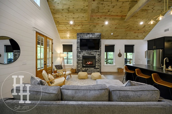 Living area with couch, designer chairs, gas fireplace, and smart TV.