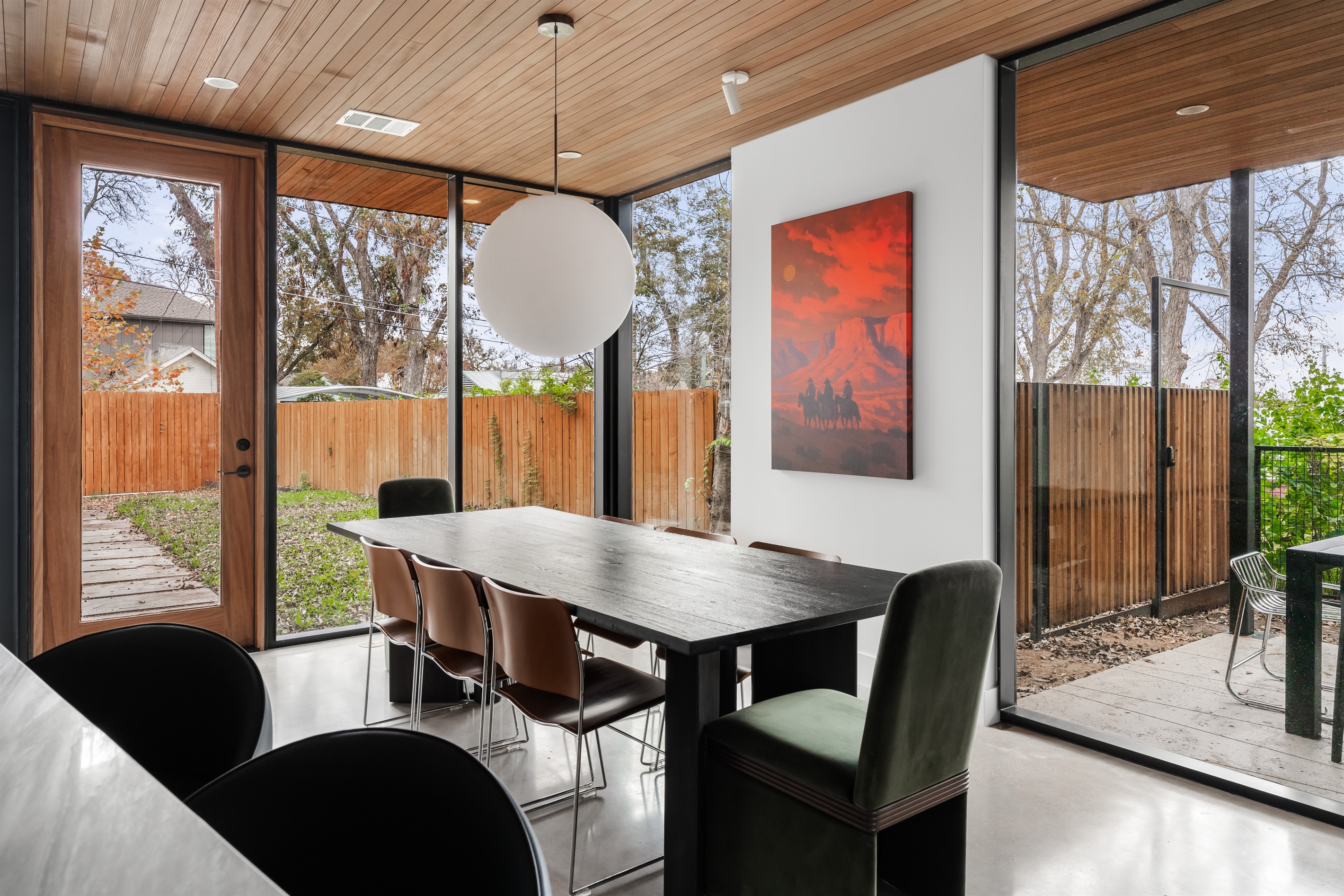Sun-filled dining space surrounded by large windows—enjoy meals with views of the backyard and fresh air.