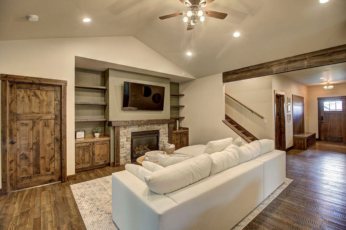 Curl up on the oversized sectional by the fire, warm and inviting living room featuring a stone fireplace, built-ins.