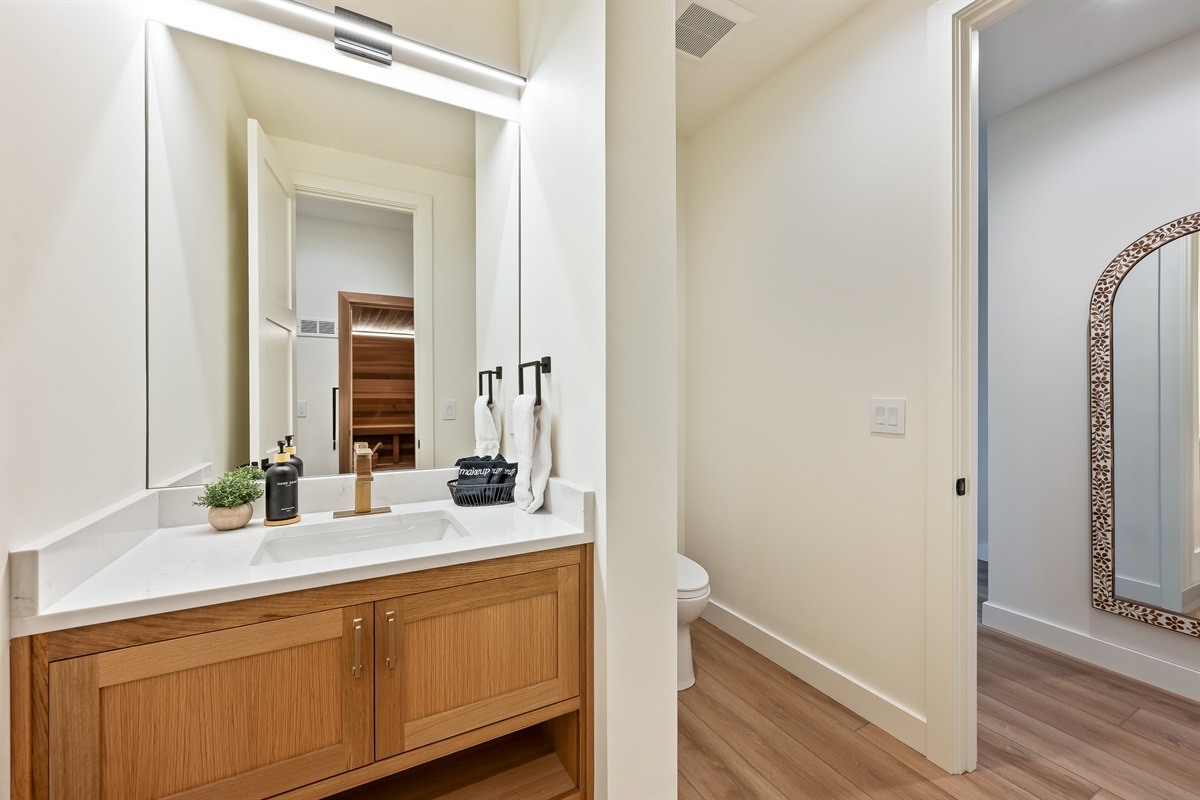 Bathroom #3 of 8 - Main floor half bath, adjacent to indoor sauna and indoor steam room and shower and hallway to side exit/entrance