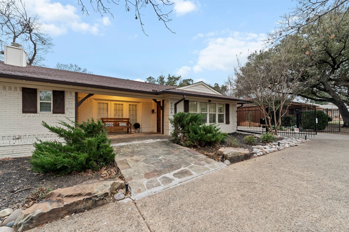 Arrive with ease to this charming home featuring a large driveway, front patio seating, and gated side access.