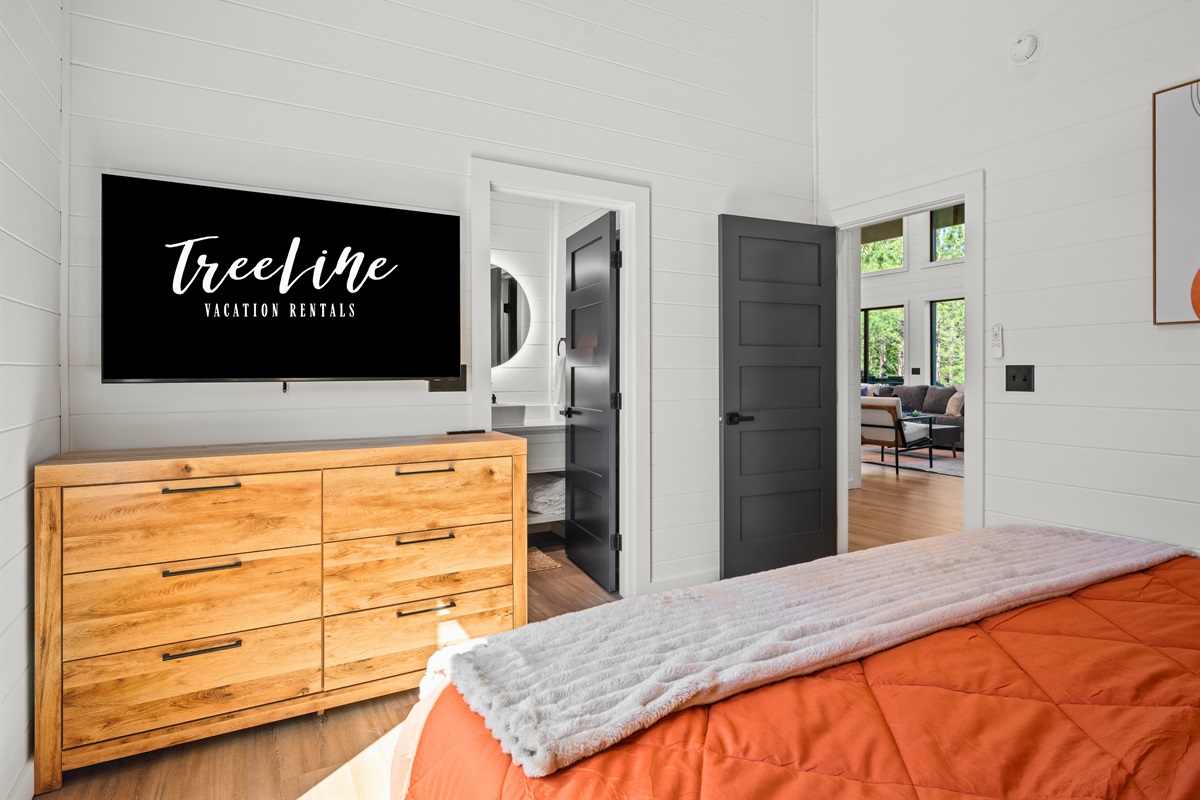 Large windows fill the room with sunlight throughout the day while keeping the space feeling connected to the peaceful outdoors surrounding the cabin.