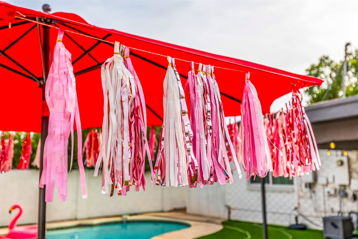 Details matter—this red umbrella with pink-and-white tassels adds a whimsical flair to your private outdoor escape.

