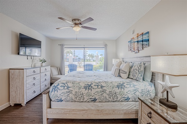 Master bedroom with patio access, ceiling fan and smart TV