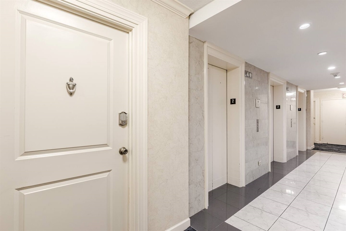 Clean, airy hallway connecting rooms w/ a bright, welcoming feel.