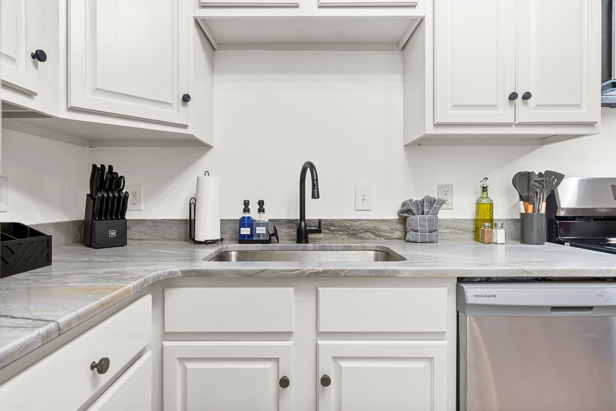 A close-up look at the modern and functional kitchen sink area, complete with all the essentials to make your cooking experience stress-free.