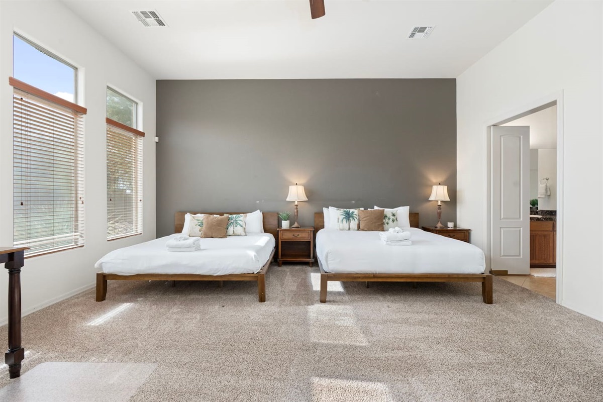 Well-appointed master bedroom offering two king beds, a comfortable work desk and chair, and a TV—perfect for balancing work and relaxation.