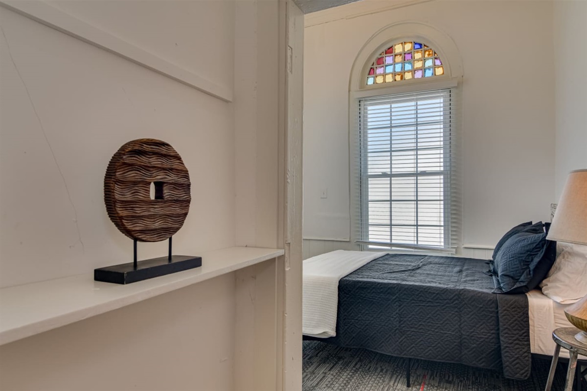 Guest suite with cozy queen bed and tall window with room darkening shades.