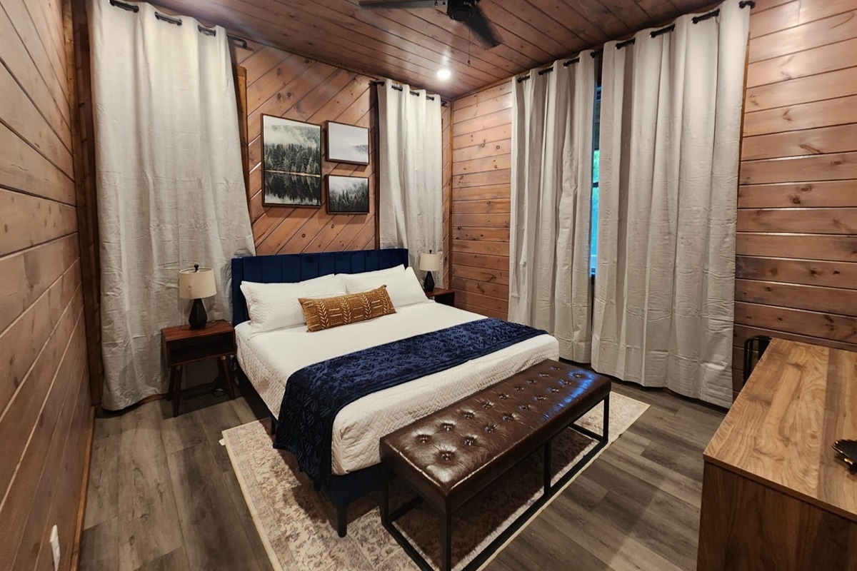 Spacious king bedroom with warm wood finishes and cozy charm.