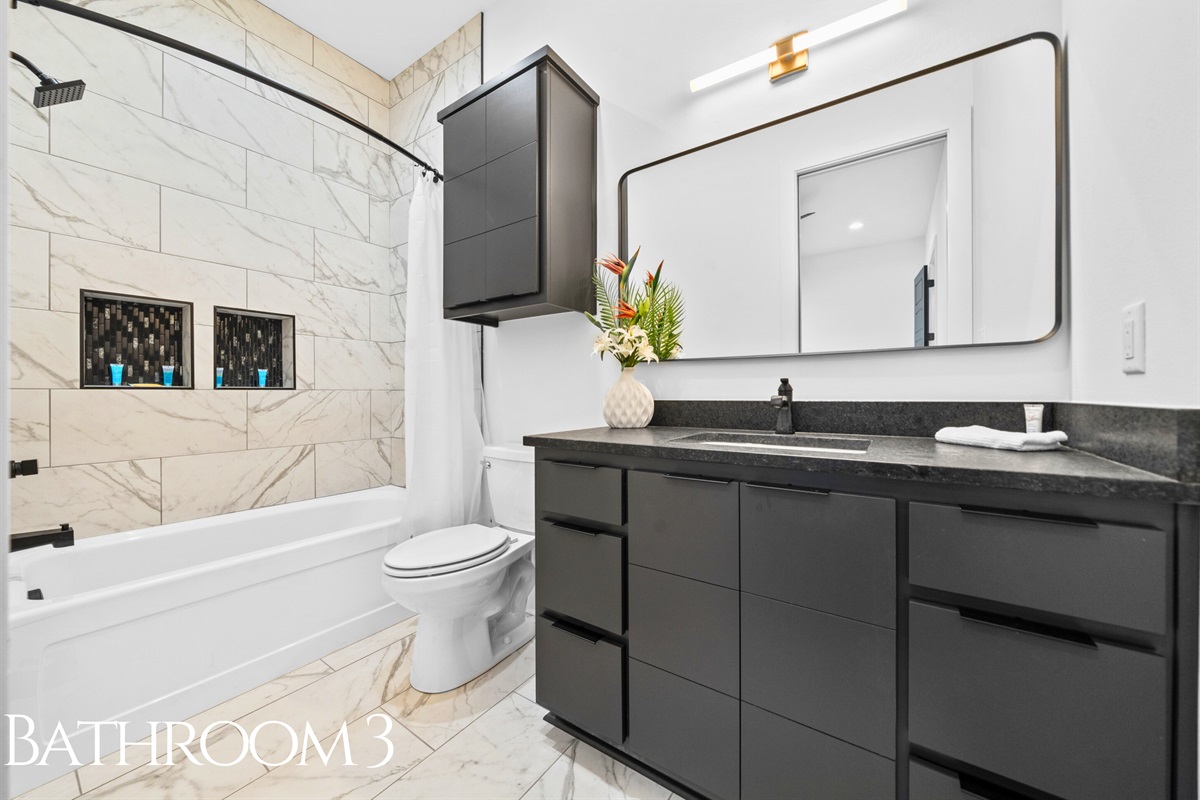 A sleek and functional bathroom featuring a shower-tub combo, and modern finishes that bring a touch of luxury to everyday routines.