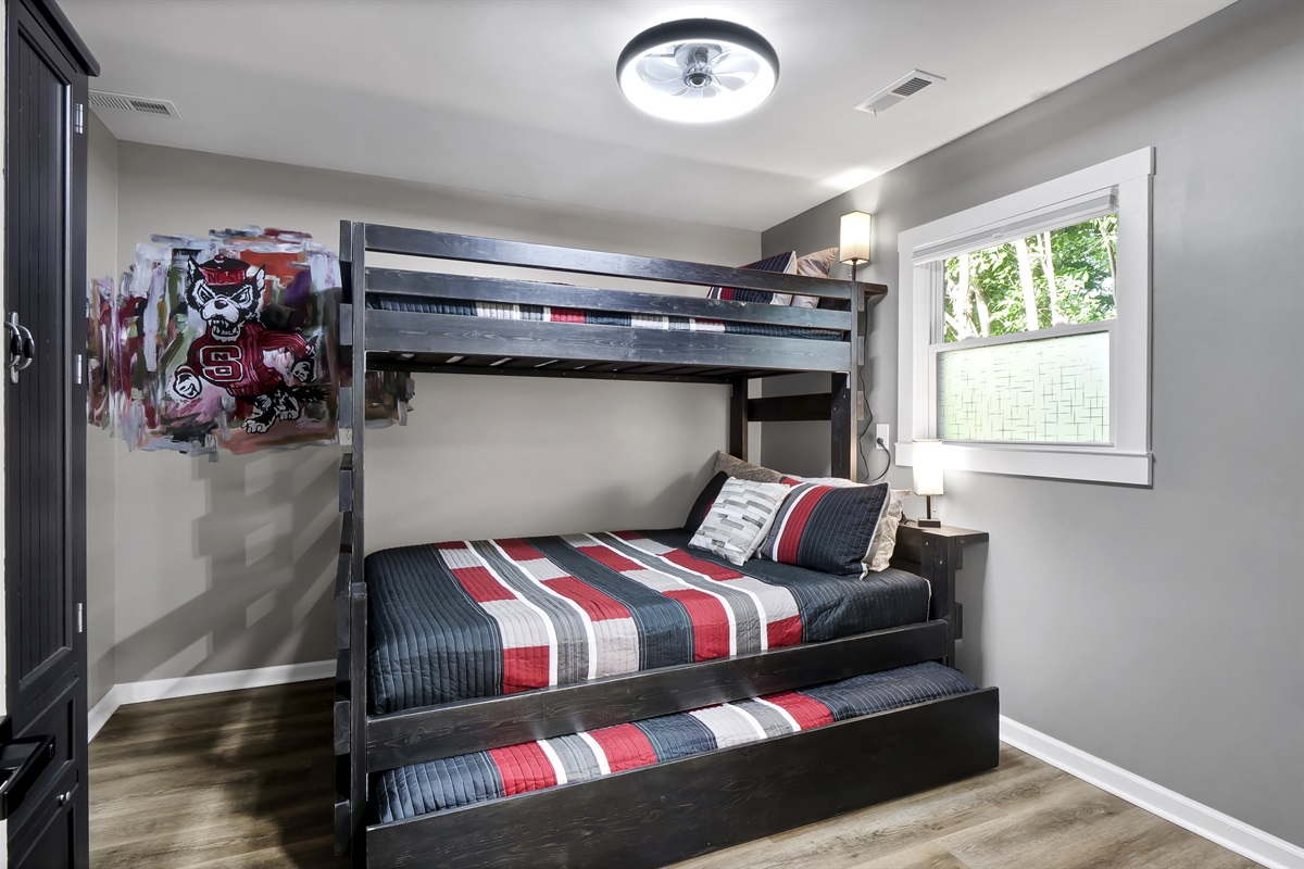 Ample space for kids in this bedroom featuring a full-sized bed and two twin beds.