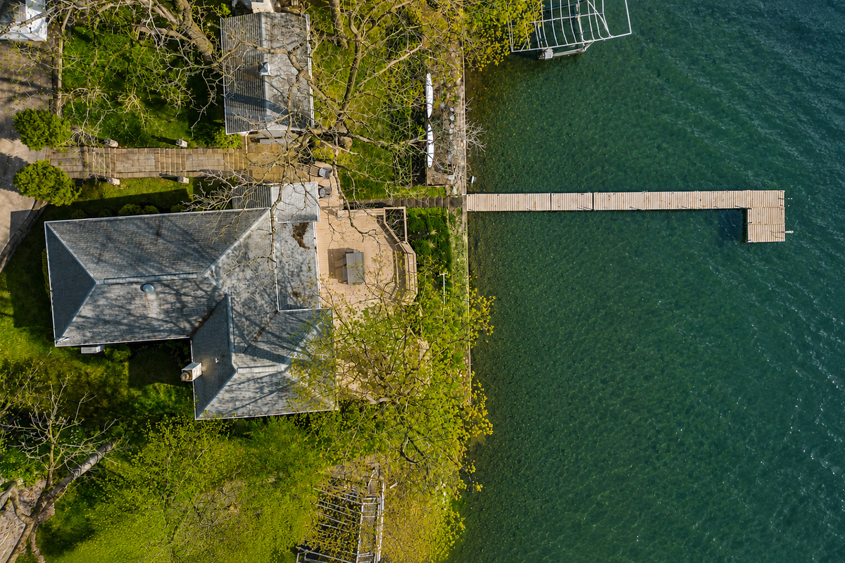 Aerial view of the property showcasing its lakeside location and private dock. Perfect for water activities, relaxing by the lake, and enjoying the natural beauty. An ideal retreat for outdoor enthusiasts!