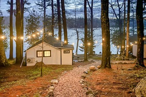 Sunset pictures with string lights staring loon cabin with lake in the background