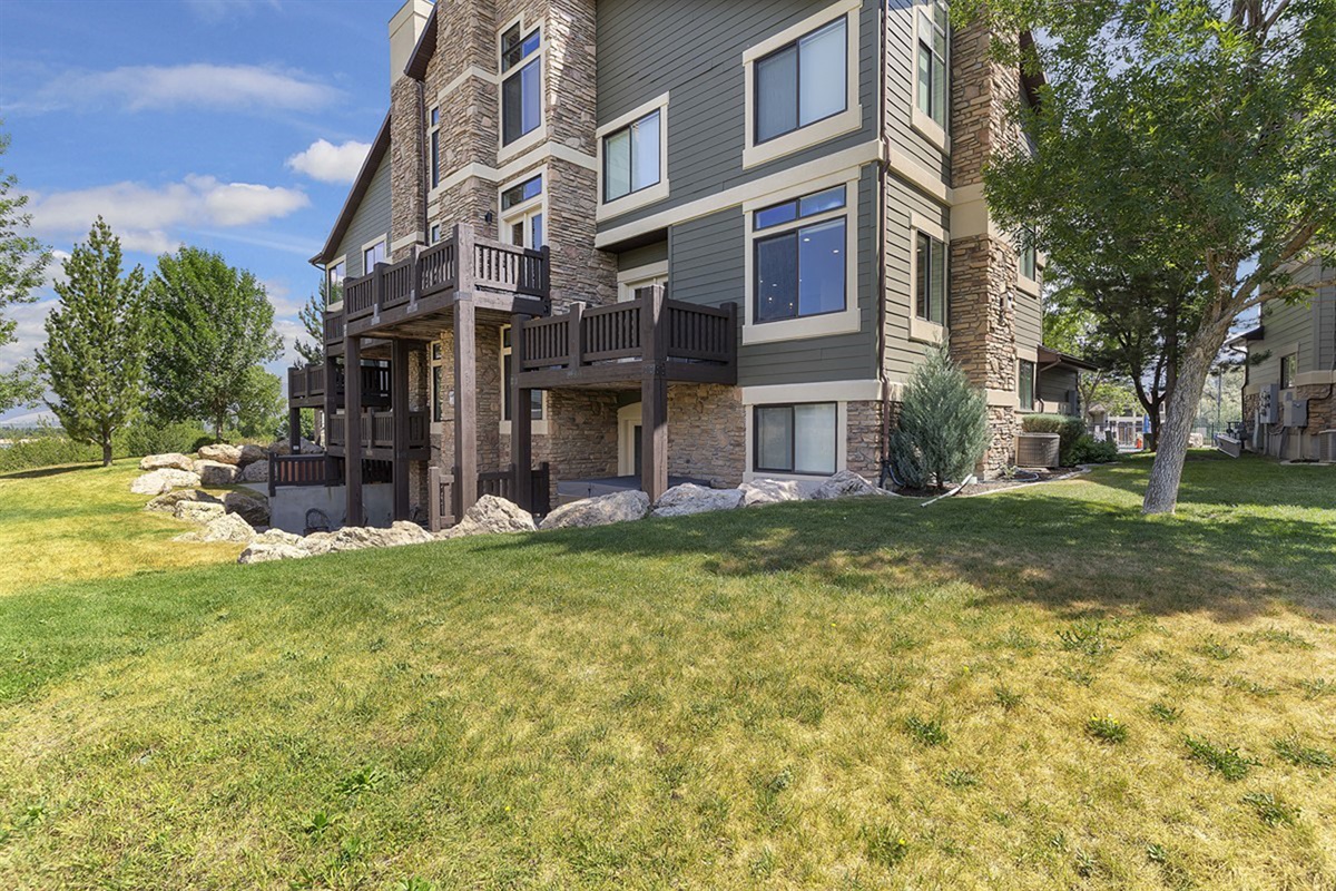 The rear exterior showcases expansive green space and refined craftsmanship, offering a peaceful retreat where nature and luxury coexist seamlessly.