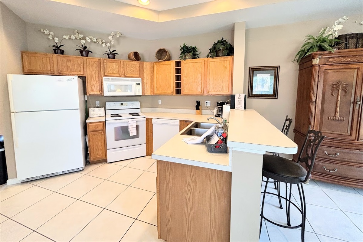 Spacious kitchen with plenty of cabinet storage, full-size appliances, a breakfast bar, and an open layout that flows into the dining and living areas.