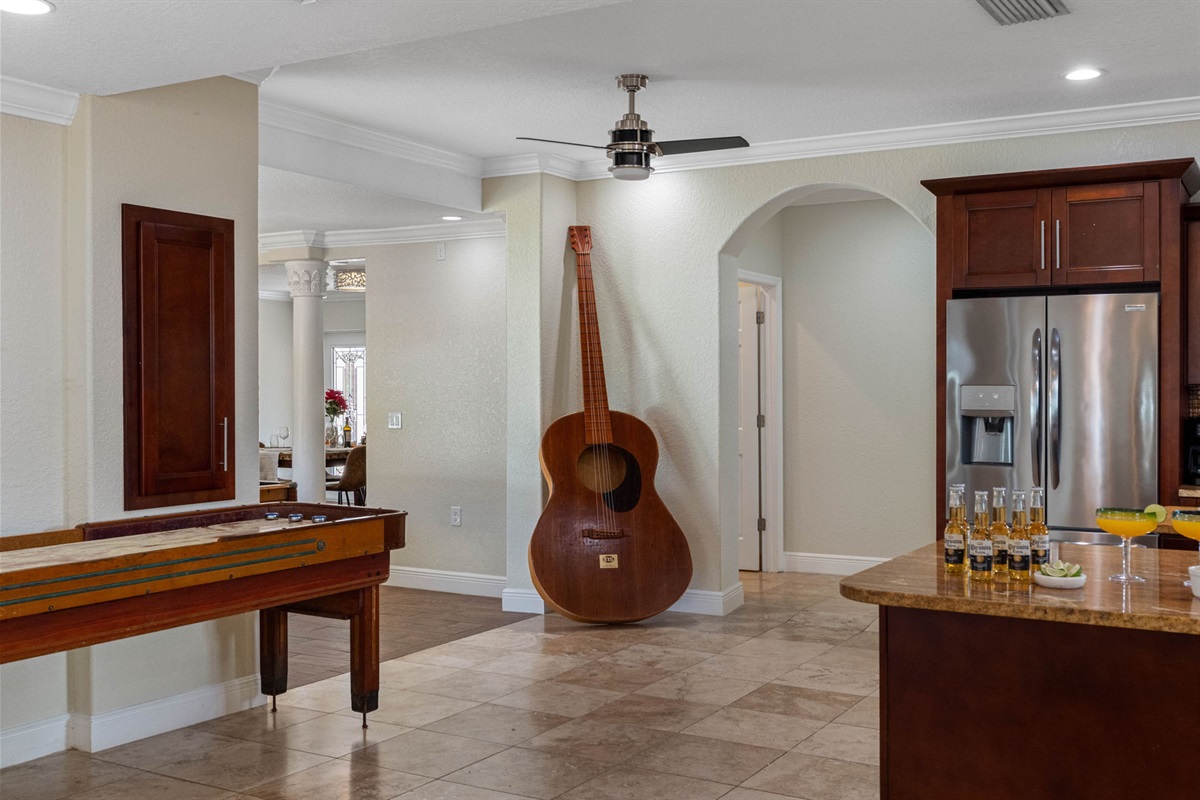 Natural light, neutral tones, and a shuffleboard table create a welcoming atmosphere for leisure.