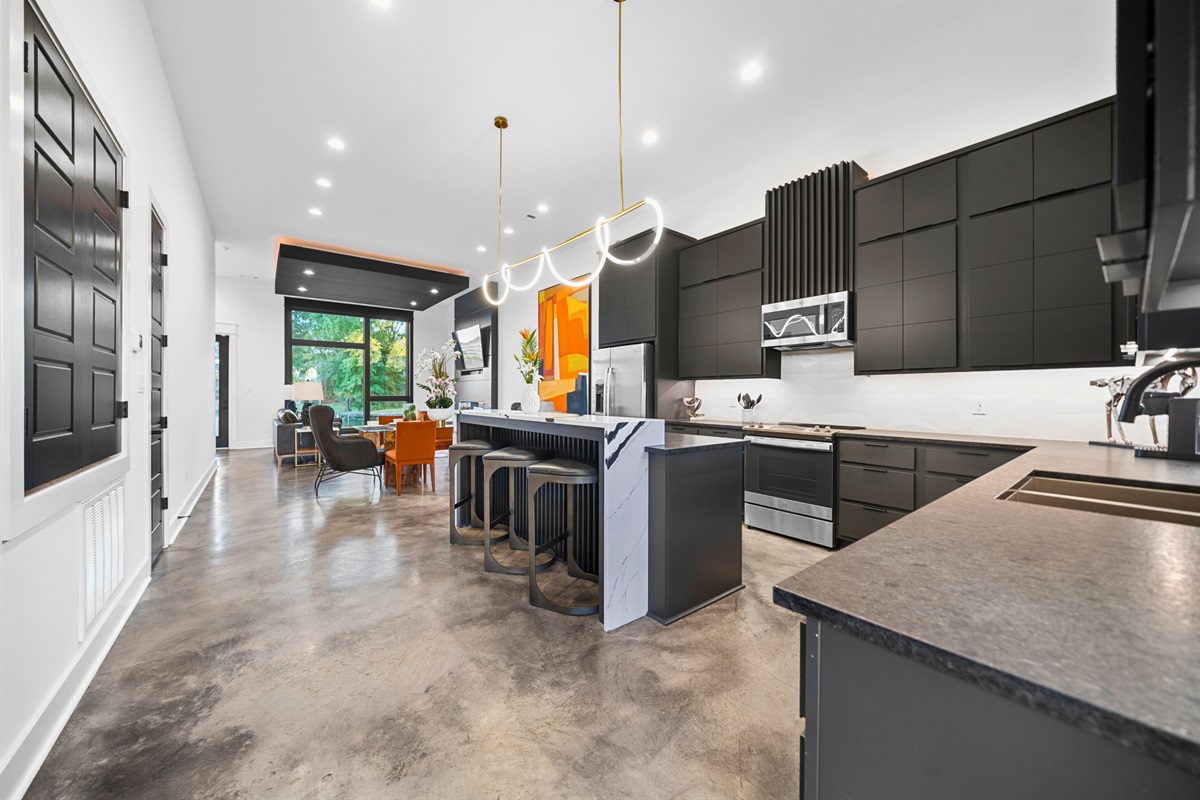 The open-concept layout showcases a sleek kitchen with high-end finishes, seamlessly flowing into the rest of the home for easy entertaining.