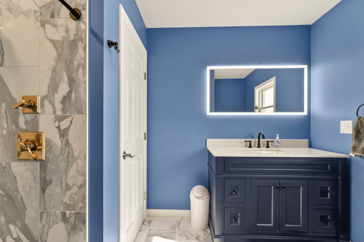 Blue bathroom with vanity and wall mirror