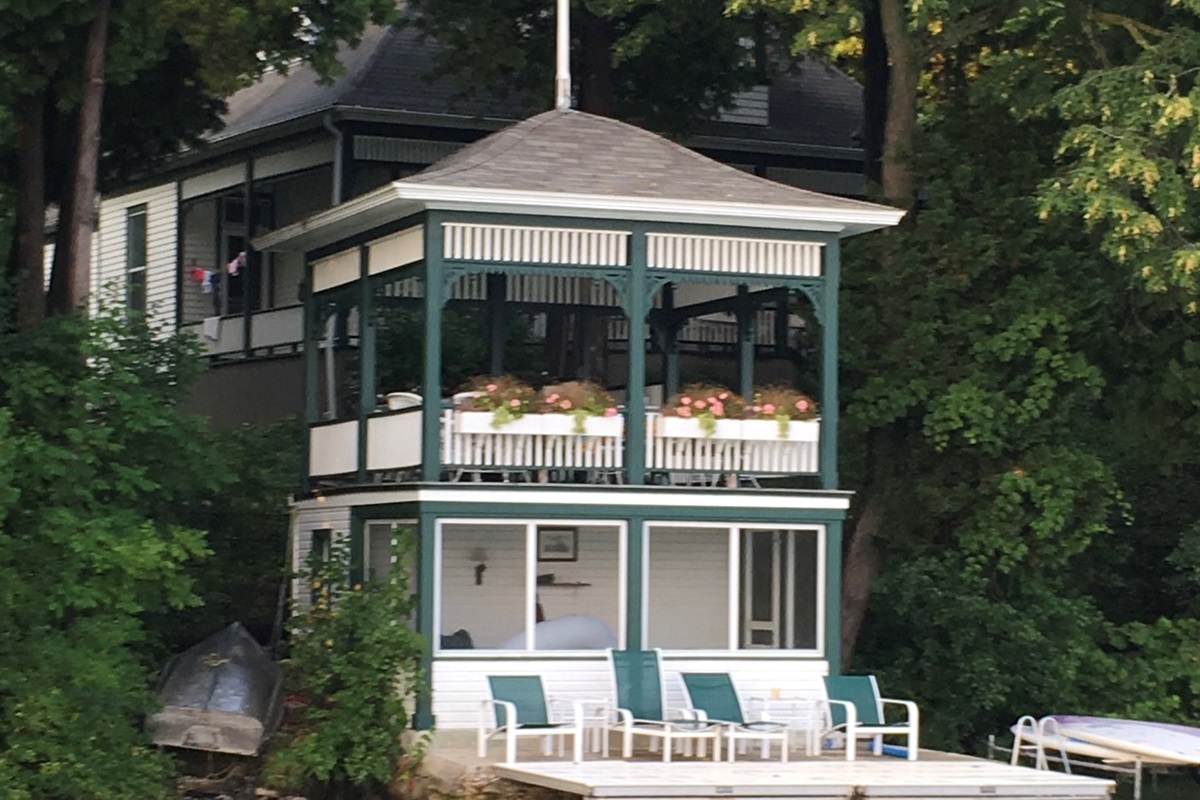 Screened lakeside porch w/ dining table for breezy outdoor meals