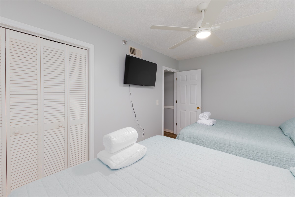 Charming Back bedroom with TV, clothing space and stylish furnishings