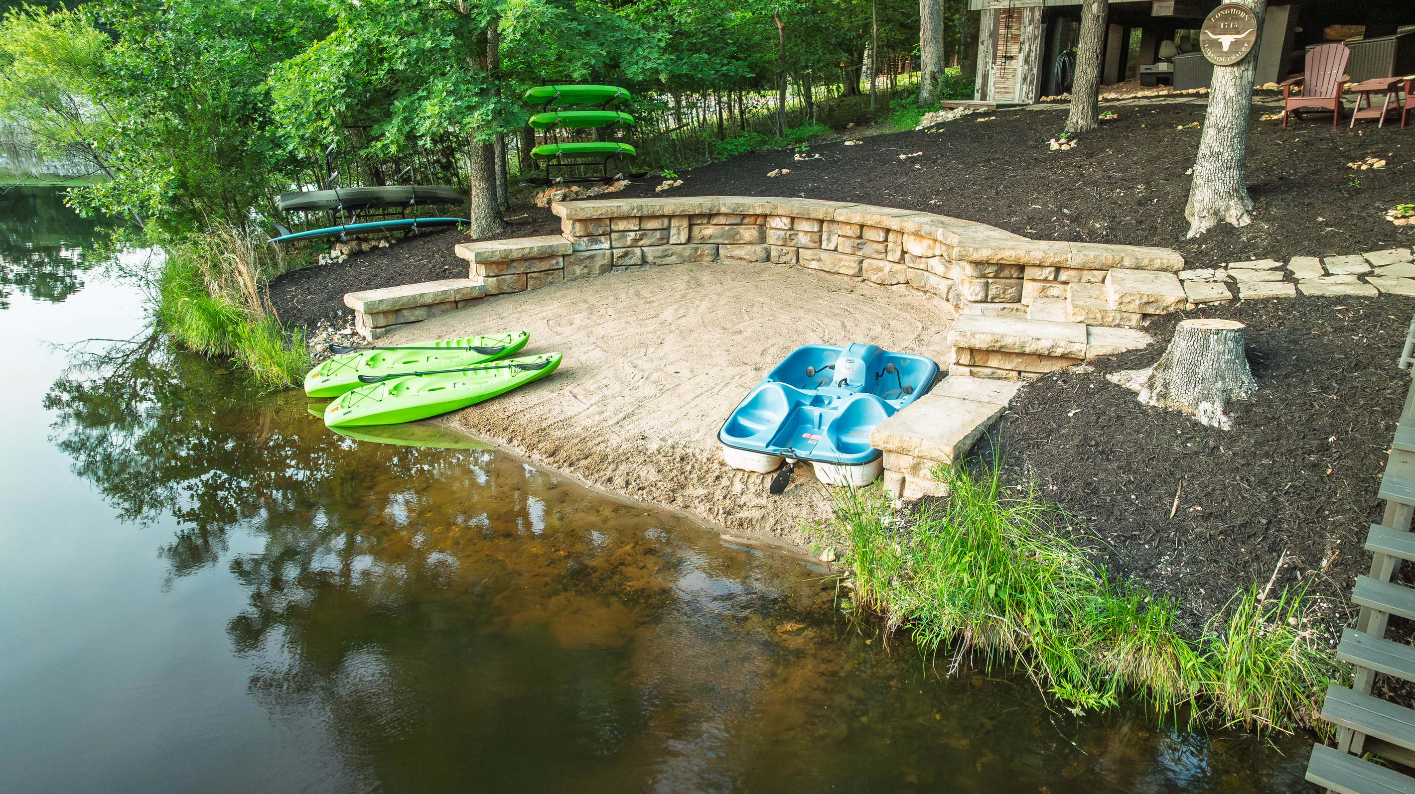 Sandy beach with kayaks and paddle boat included for guests.