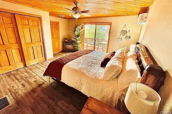 This bedroom features a lake view, king size adjustable bed, electric fireplace, en suite bathroom, and sliding glass door onto the balcony.