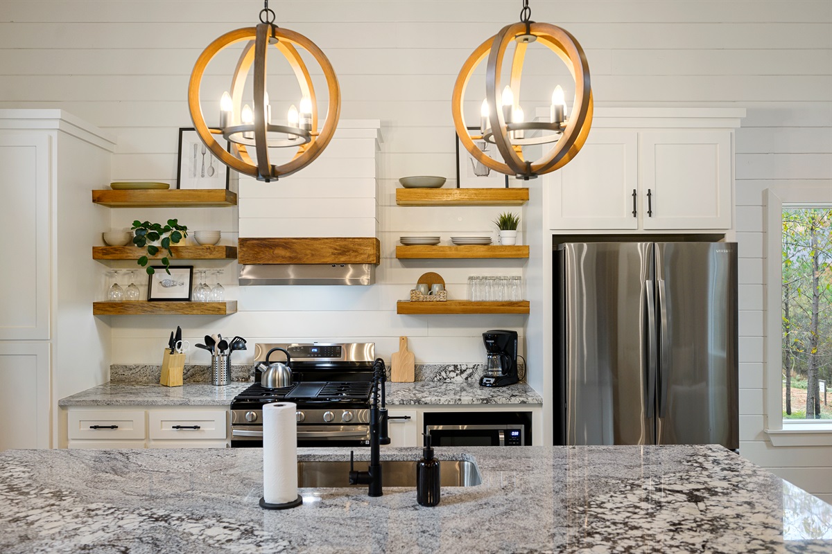 Luxury kitchen details that make staying in feel just as good as going out. 
Granite countertops, modern appliances, open shelving, and the kind of warm gathering space that naturally becomes the heart of the cabin.