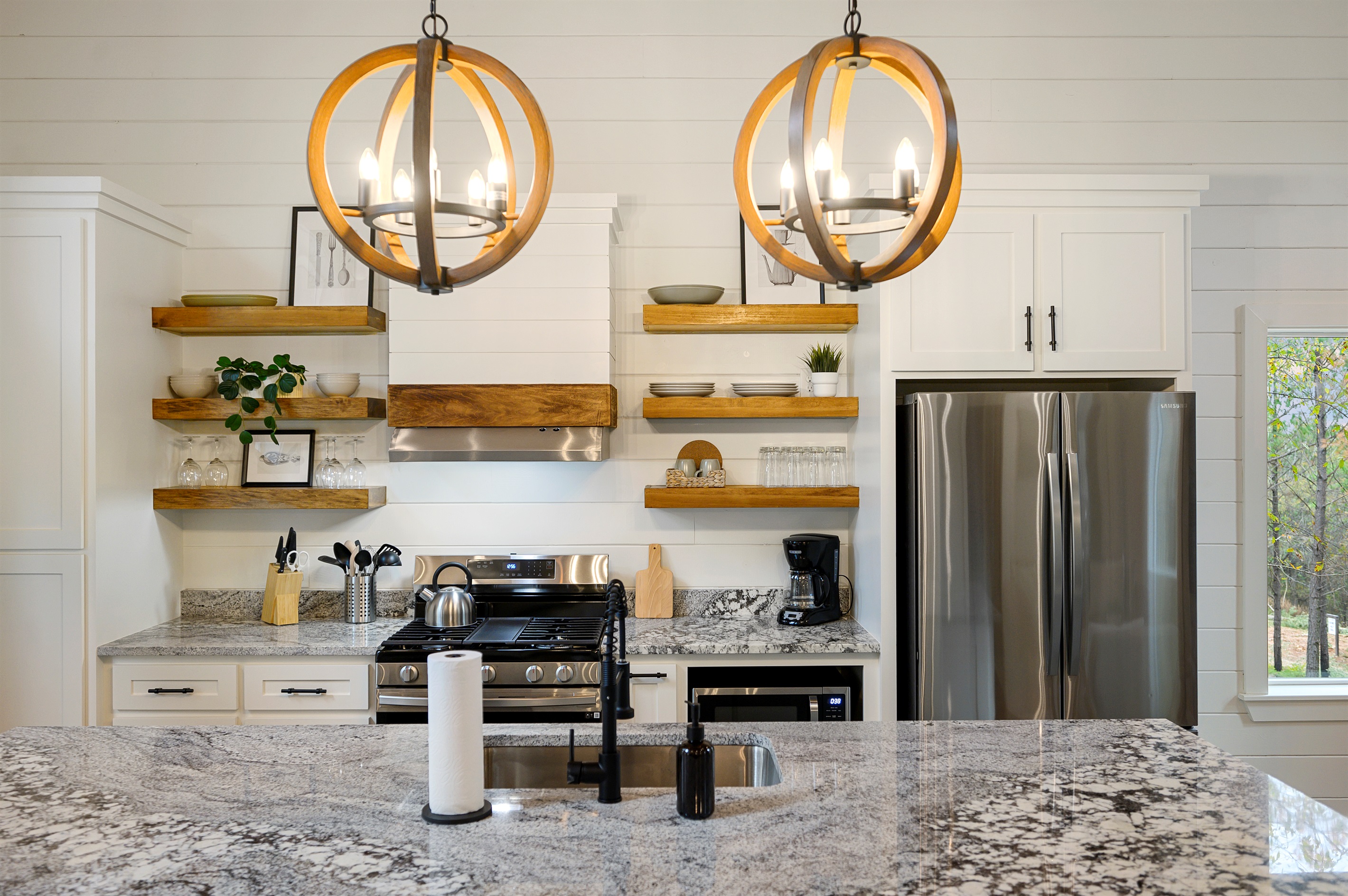 Luxury kitchen details that make staying in feel just as good as going out. 
Granite countertops, modern appliances, open shelving, and the kind of warm gathering space that naturally becomes the heart of the cabin.