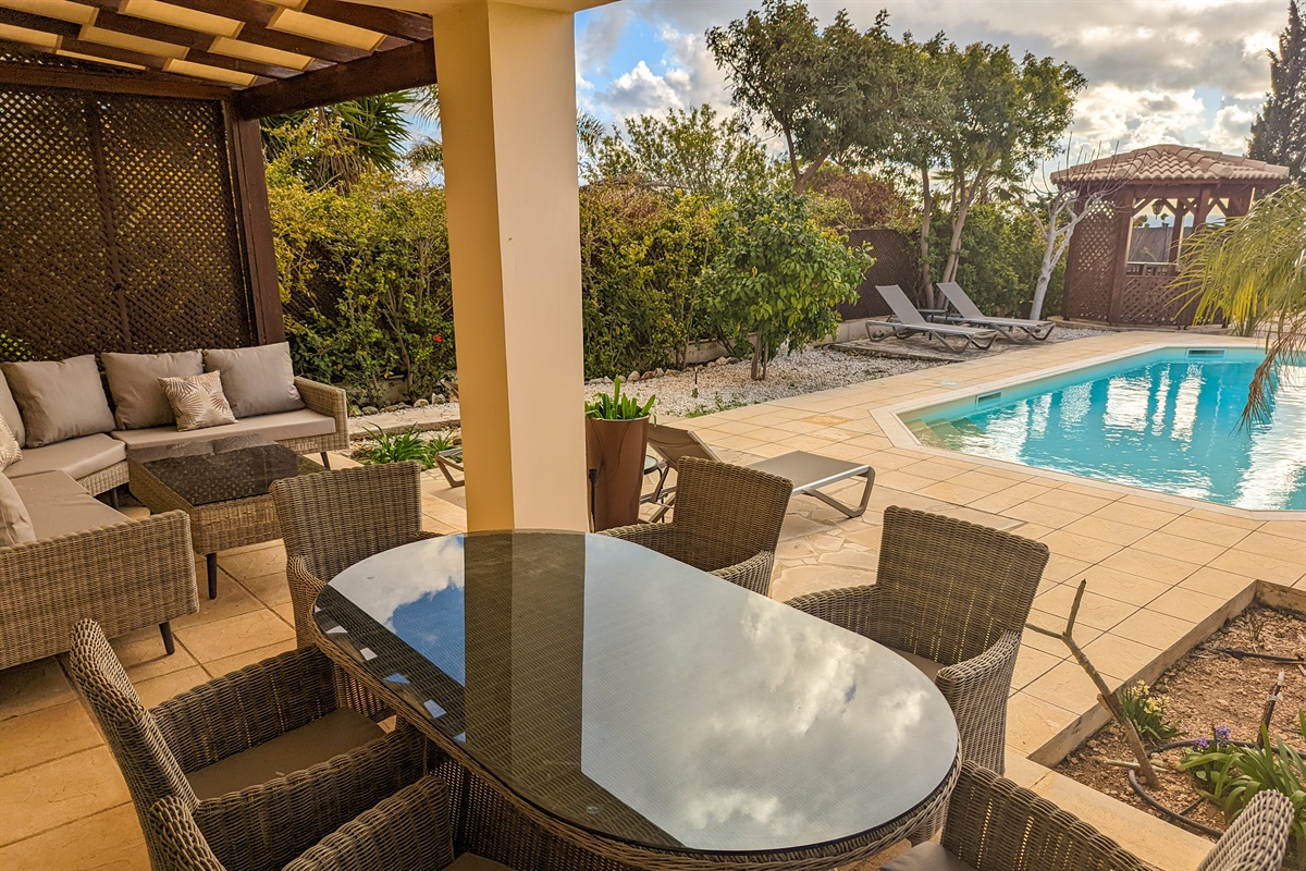 The outdoor dining table and lounge sofa sit right by the pool, making it easy to keep an eye on kids as they swim and play.