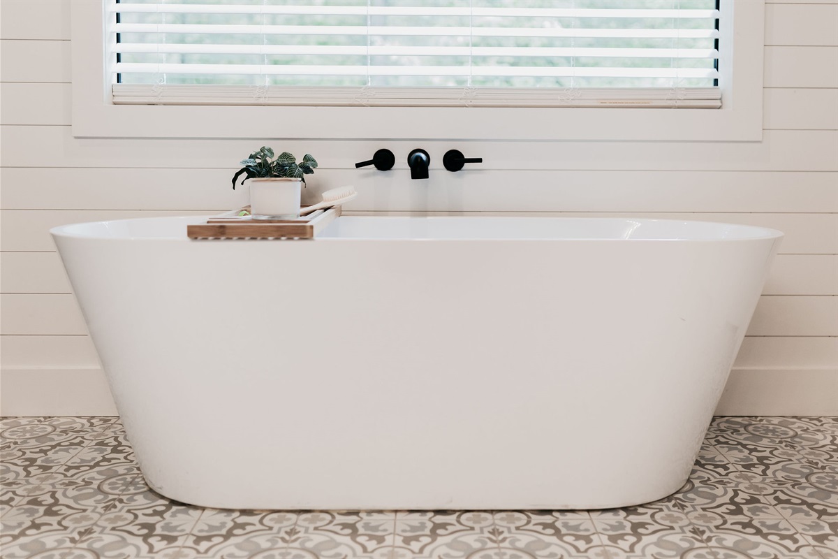 Bathroom Bliss: Spacious walk-in shower and freestanding tub with serene forest views!